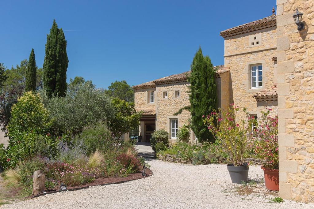 an old stone building with a garden in front of it at Le Mas des Alexandrins in Uzès