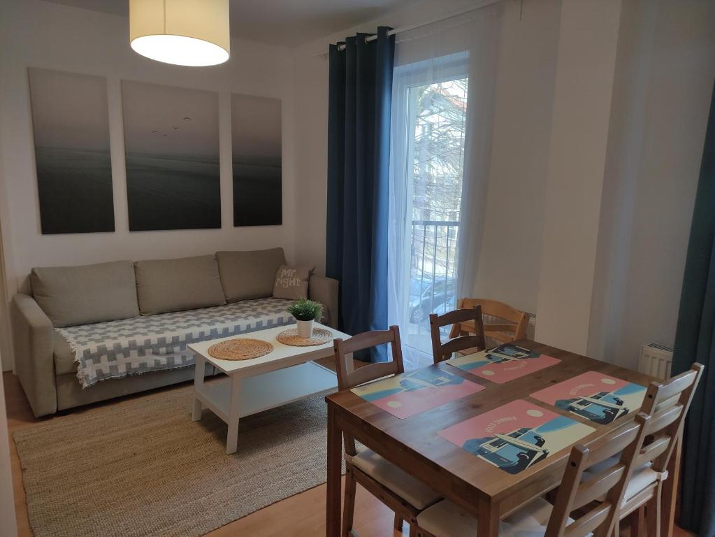 ein Wohnzimmer mit einem Tisch und einem Sofa in der Unterkunft centrumplażaGiżycko in Giżycko