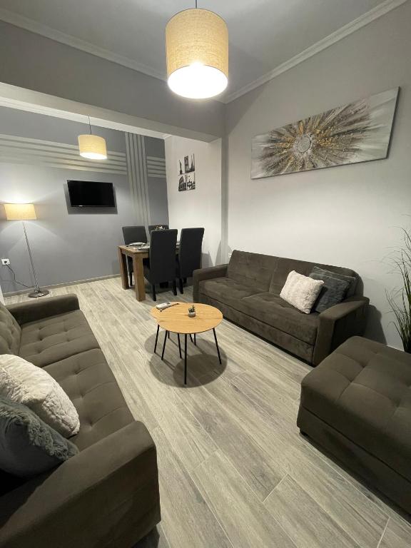 a living room with a couch and a table at DT Luxury Apartment in Nea Peramos