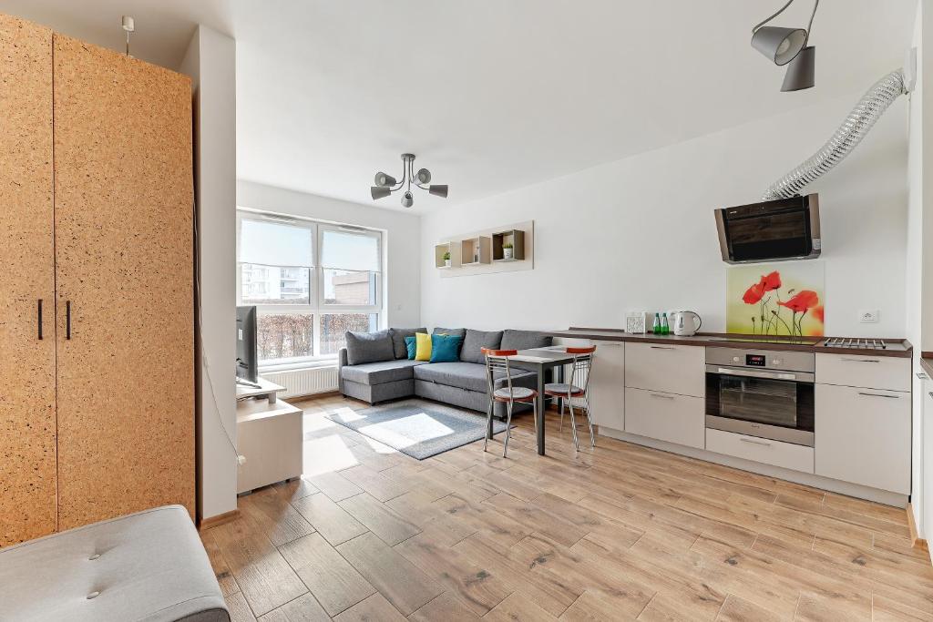 cocina y sala de estar con sofá y mesa en Spektrum by Grand Apartments en Gdansk