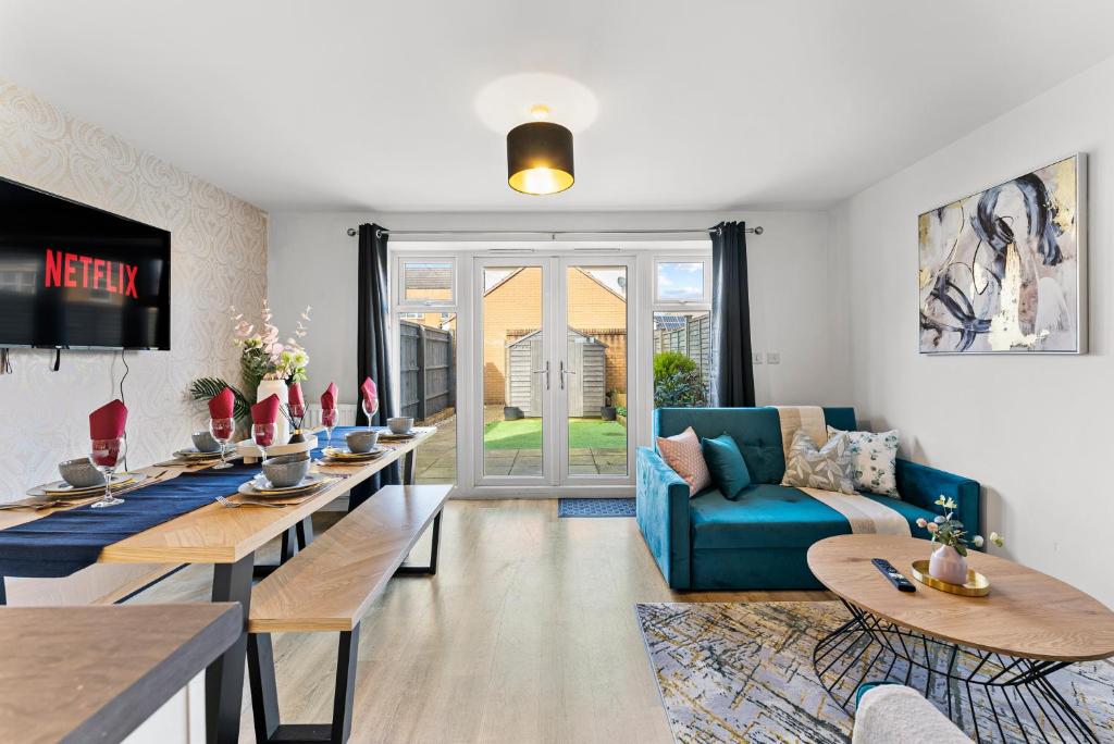 a living room with a blue couch and tables at Captivating 4 bed House - Parking - Sleeps 14 in Bristol