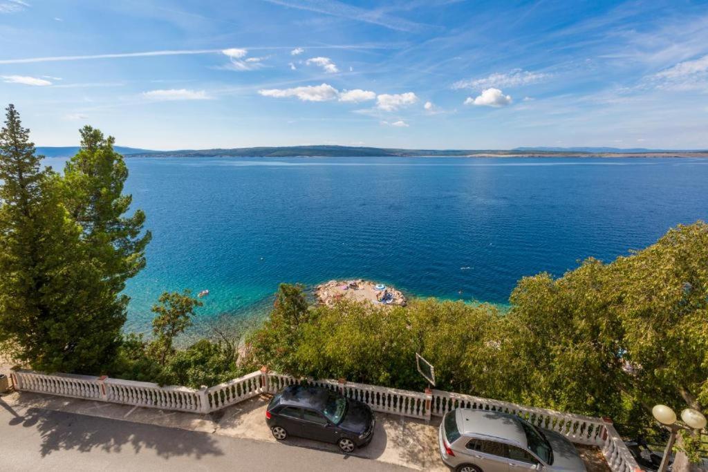 two cars parked next to a large body of water at Apartment Golden Sun in Dramalj
