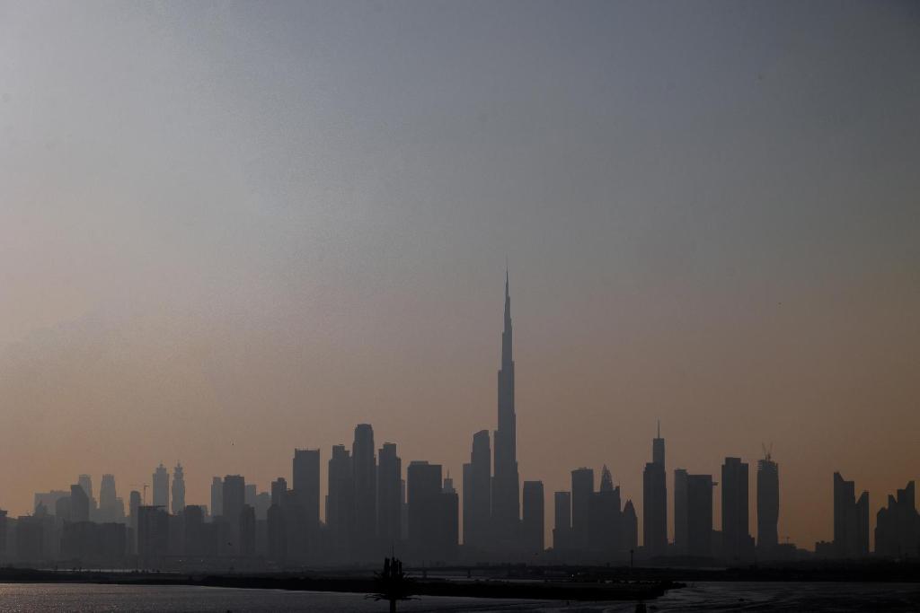 a skyline of a city with the tallest building at Burj Khalifa View & Creek lagoon in Dubai