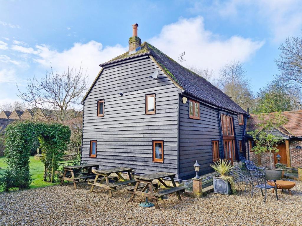 ein großes Haus mit Picknicktischen davor in der Unterkunft Walnut Barn - Horsham in Horsham