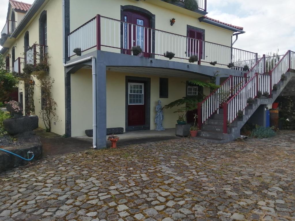 a house with a staircase in front of it at Apartamento Solar dos Castanheiros in Prainha de Baixo