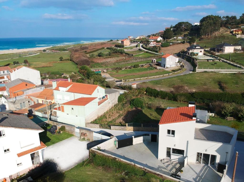 ein Luftblick auf ein Dorf mit Häusern und das Meer in der Unterkunft AG Casa do Ramon en Playa Razo con patio exterior in A Coruña