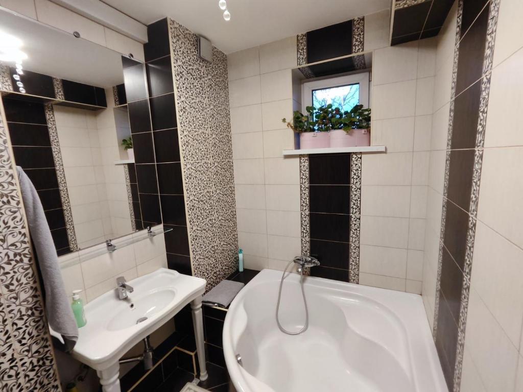 a bathroom with a white tub and a sink at Golden Rose in Chişinău