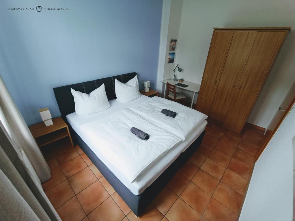 a bedroom with a bed with two slippers on it at Ferienwohnung Strandmuschel in der Villa Daheim in Juliusruh in Breege