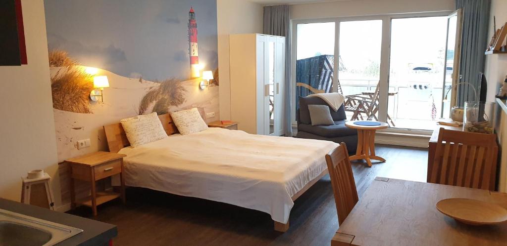 キュールングスボルンにあるYachthafenresidenz-Wohnung-9205-917のベッドルーム(大型ベッド1台付)、リビングルームが備わります。