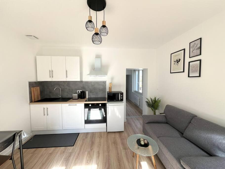 a living room with a couch and a kitchen at Maison Cosy à Saint-Dizier in Saint-Dizier