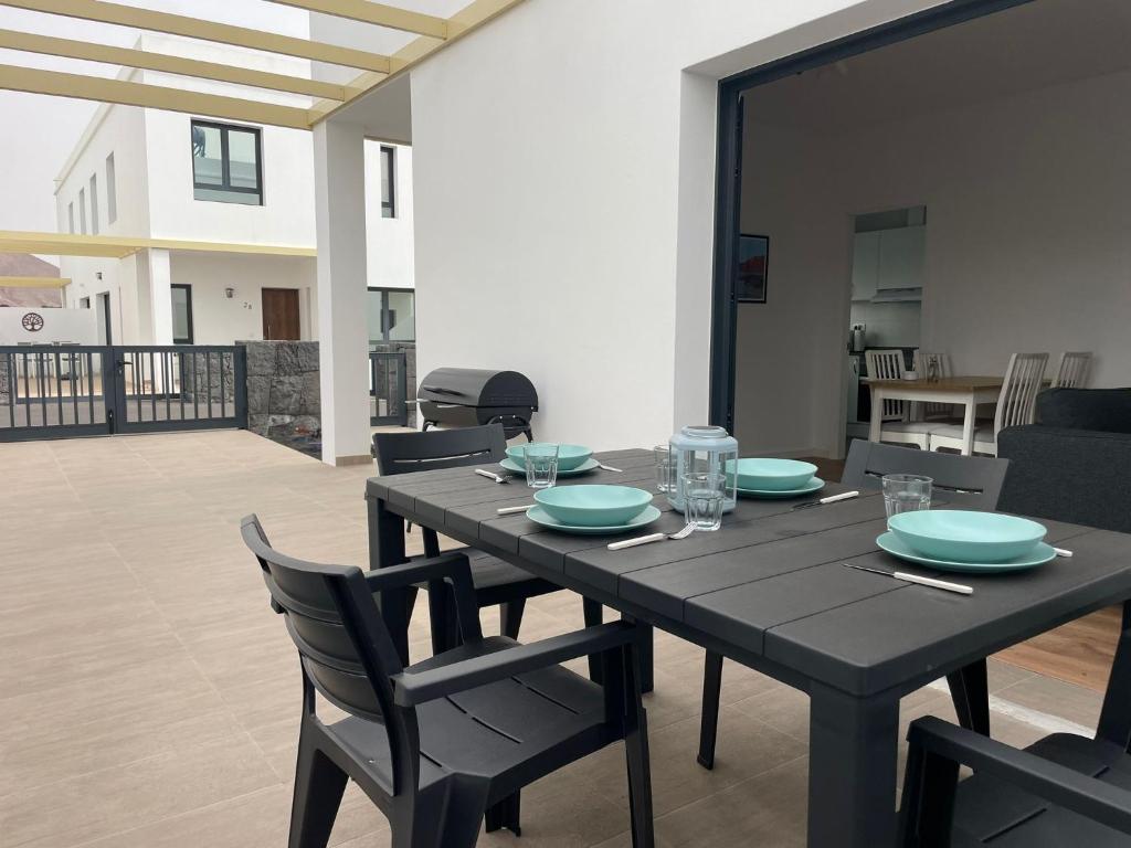 a black table with chairs and plates on it at Villa Patricia in Costa Teguise
