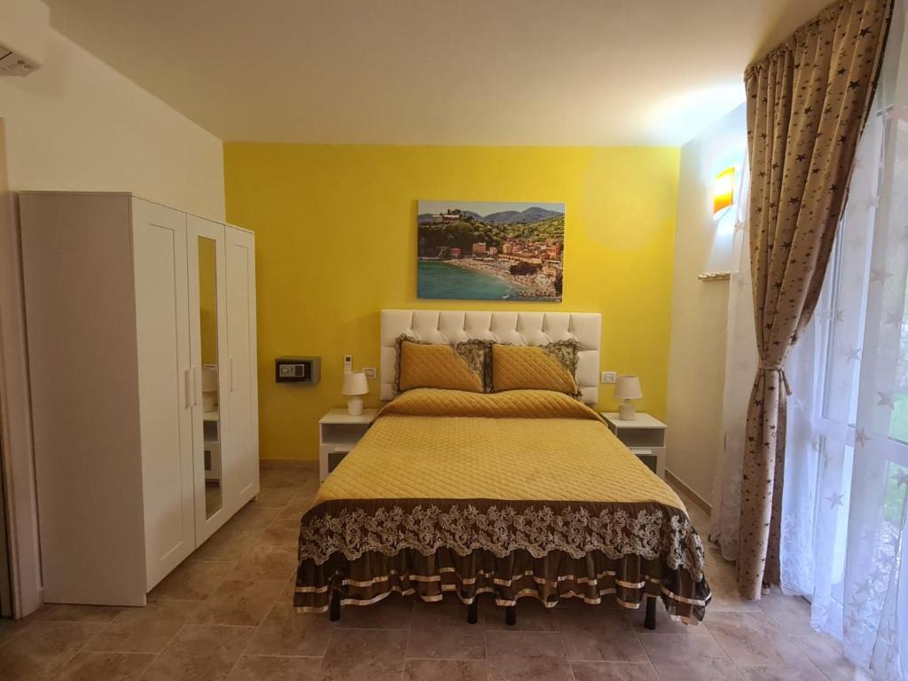 1 dormitorio con 1 cama grande y paredes amarillas en Agriturismo La Collina Verde, en Levanto