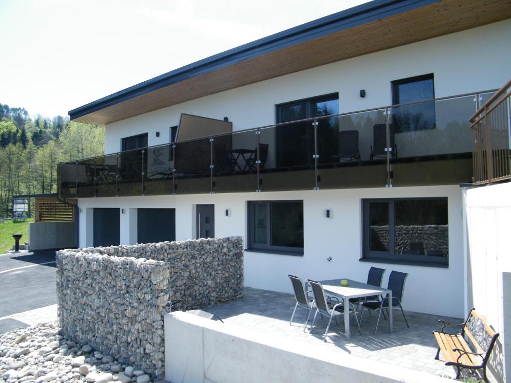 a building with a balcony with a table and chairs at Haus Schloßbergblick in Leutschach