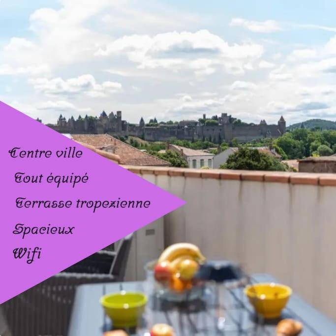 une pancarte rose assise sur une table avec de la nourriture dans l'établissement La Majestueuse Cité, à Carcassonne