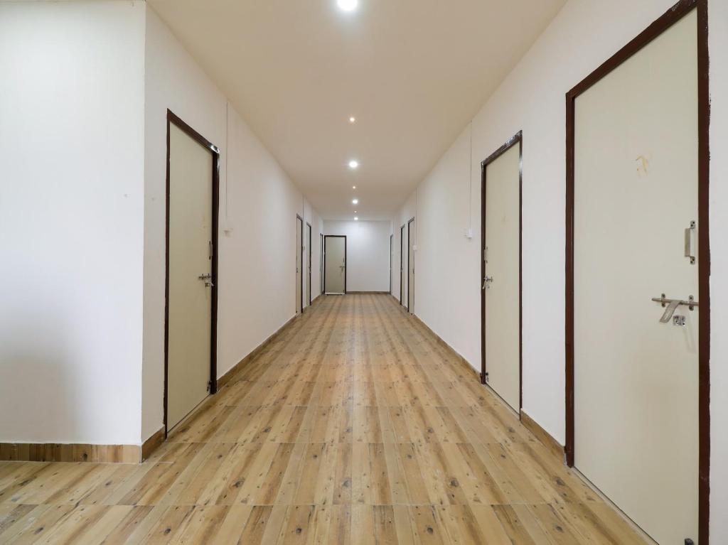 an empty hallway with doors and wooden floors at Super OYO Flagship Kompally Residency in Hyderabad