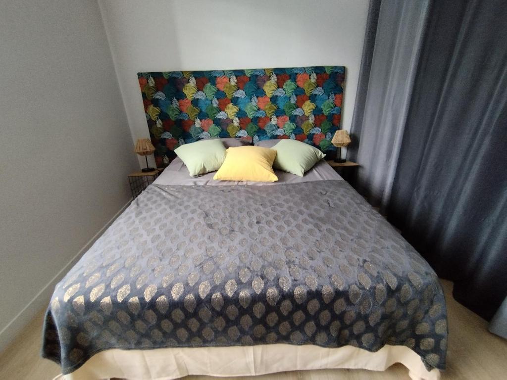 Dormitorio con cama grande y cabecero colorido en Chambre double avec piscine 15 mn du Cap d'Agde, en Saint-Thibéry