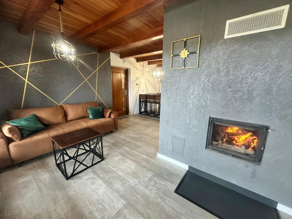 sala de estar con sofá y chimenea en Zielona Przystań, en Manasterz