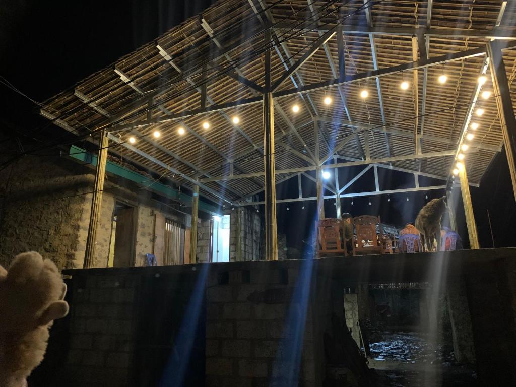 a group of people sitting at a bar at night at Nhà Cổ Bản Giốc Homestay - Làng đá Khuổi Ky in Bản Piên