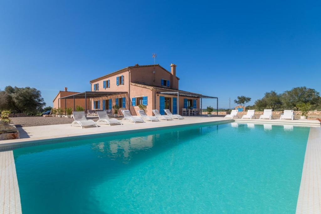 een zwembad met stoelen en een huis bij Manacor - 3085 Mallorca in Manacor