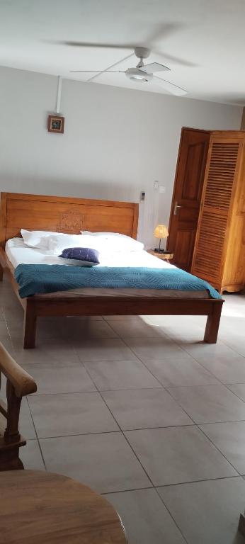 a bedroom with a large bed with a wooden headboard at Bois de Santal Chambre d&#39;hôtes in Saint-Pierre