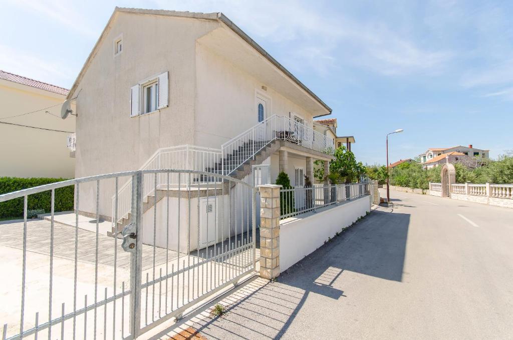a house with a fence in front of it at Apartment Oblutak in Brodarica