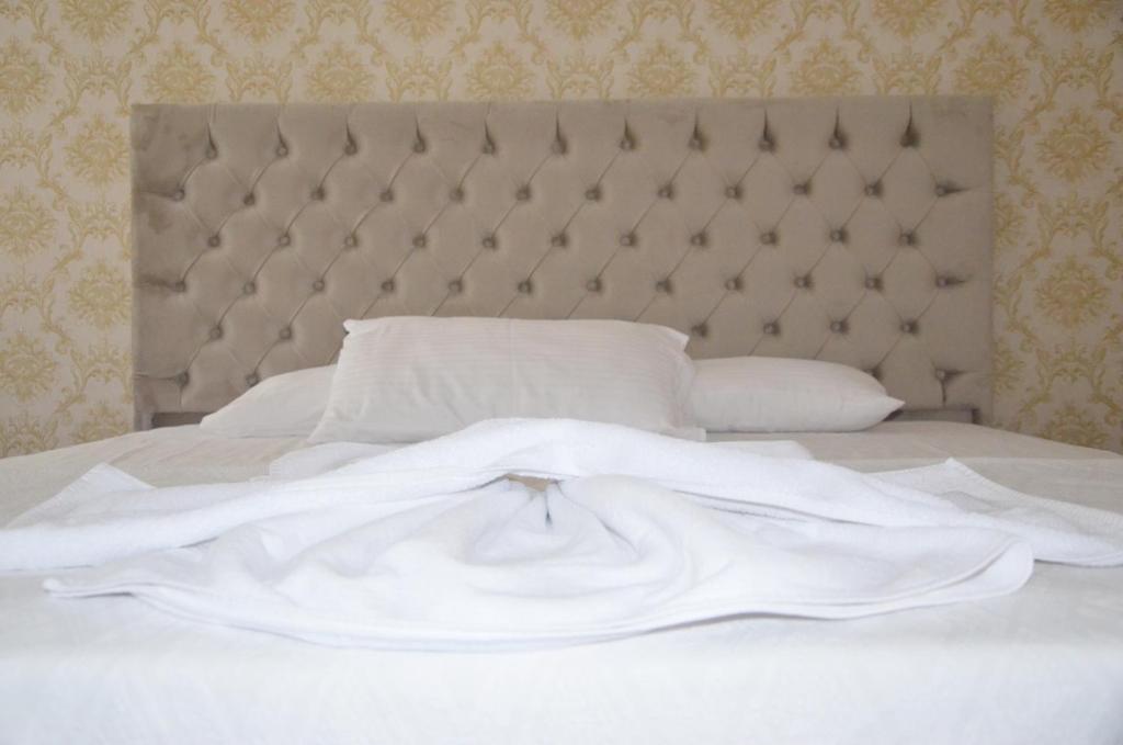 a white bed with a headboard and white sheets and pillows at MELLES OTEL in Antalya