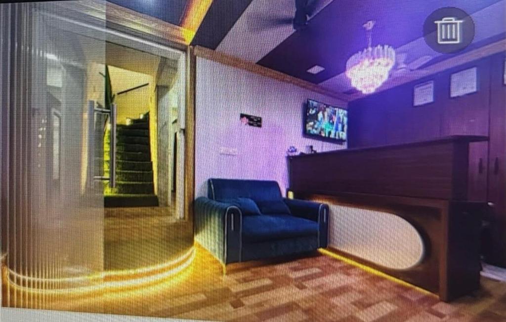 een woonkamer met een piano en een blauwe stoel bij Hotel Grand Villa in Mumbai