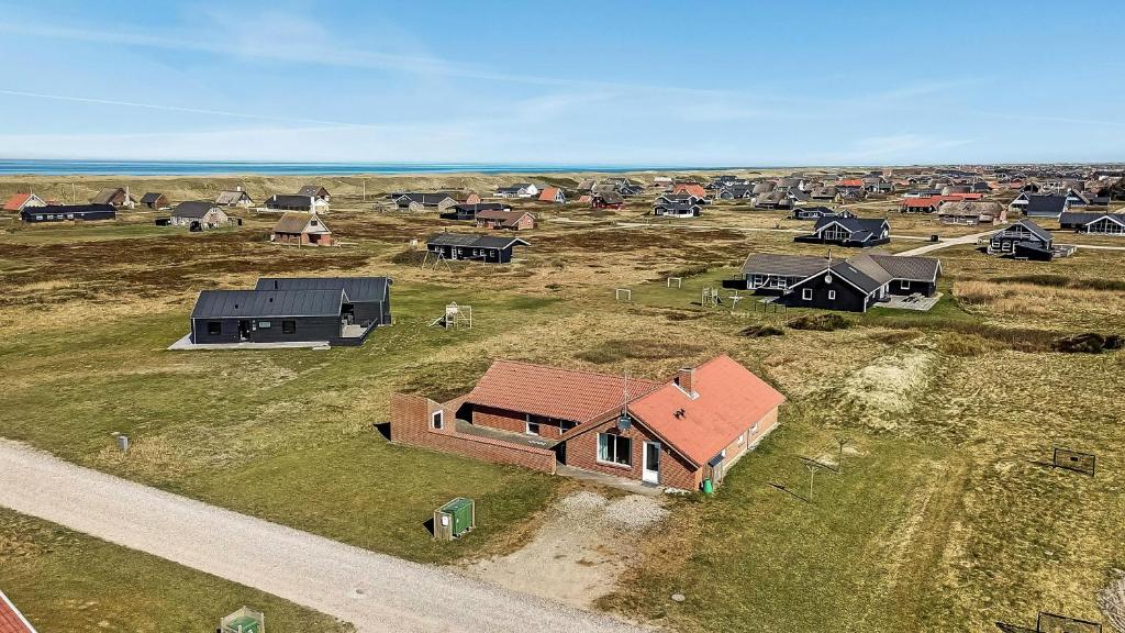 une vue aérienne d'une maison dans un champ dans l'établissement Cozy holiday house with pool by the sea - SJ940, à Harboør