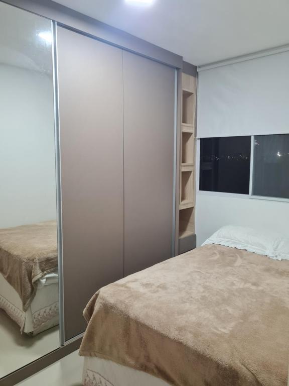 a bedroom with a bed and a large closet at Quarto privativo Interlagos autódromo in Sao Paulo
