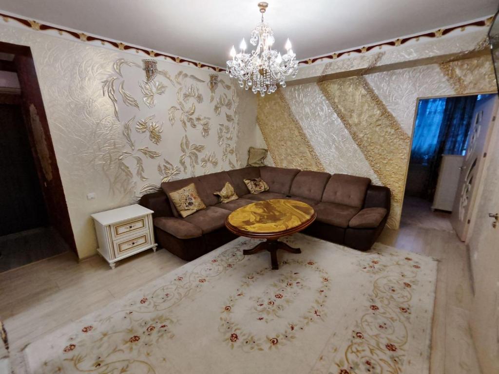 uma sala de estar com um sofá e uma mesa em Gold Rose Apartament em Chisinau