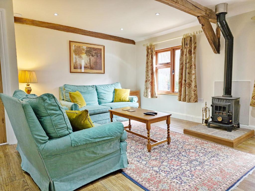 a living room with a blue couch and a wood stove at Walnut Cottage - Horsham in Horsham