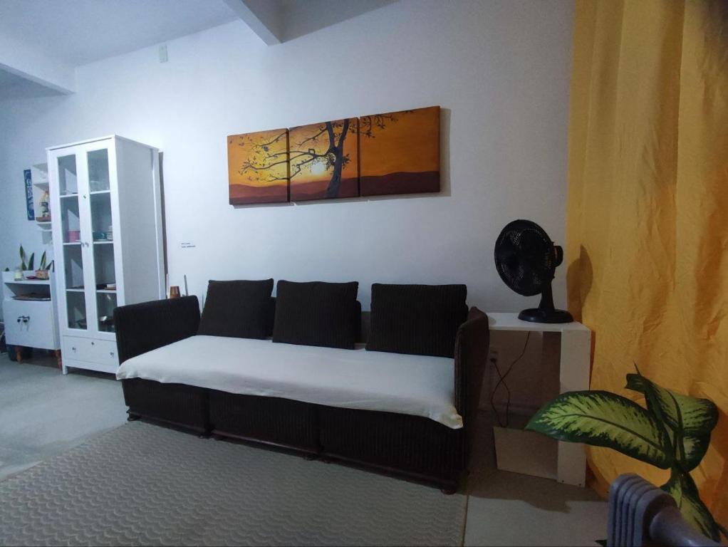 een woonkamer met een bank en een schilderij aan de muur bij Apartamento em condomínio fechado na Farolândia in Aracaju