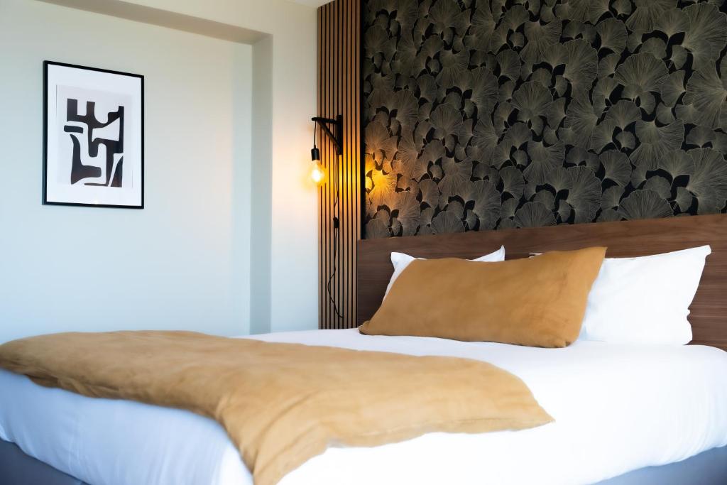 a bedroom with a bed with a black and white wall at Hôtel Mar I Cel &amp; Spa in Canet-en-Roussillon