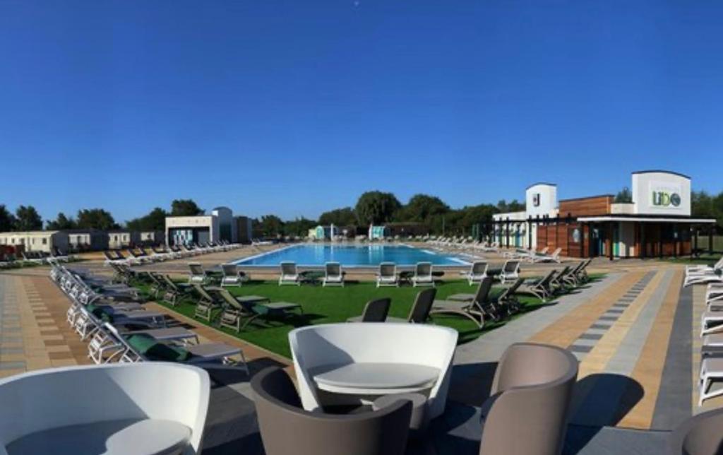 a row of chairs and a swimming pool at Shells Breaks Tattershall Lakes Shearwater 27 in Tattershall