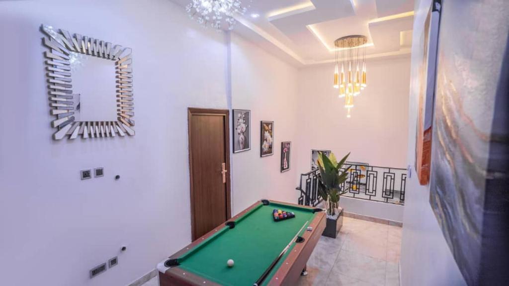 a room with a pool table and a mirror at White Orchid in Benin City