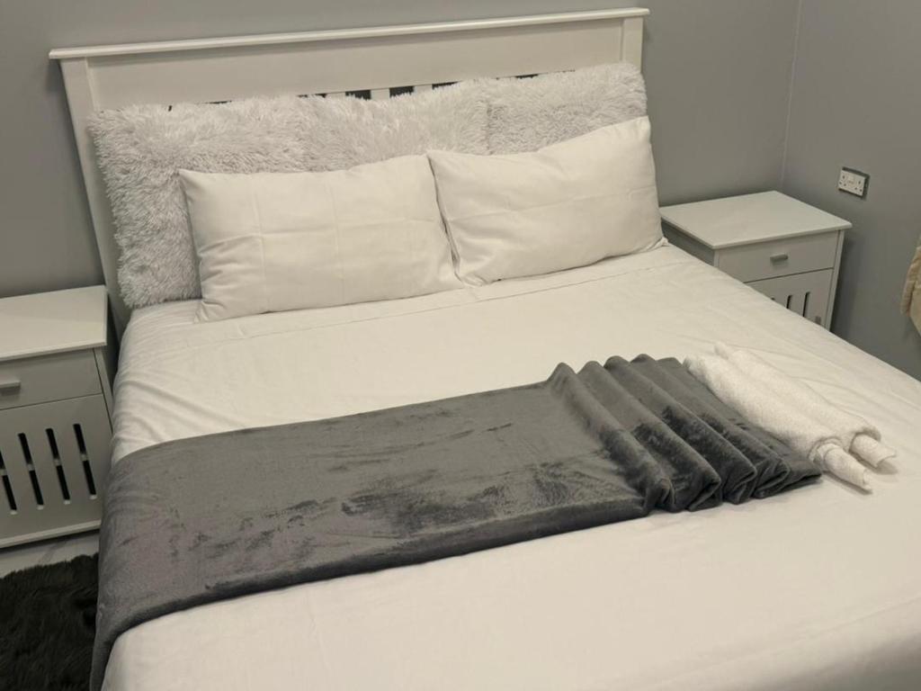 Una cama blanca con una manta encima. en Modern Village Apartments, en Chipata