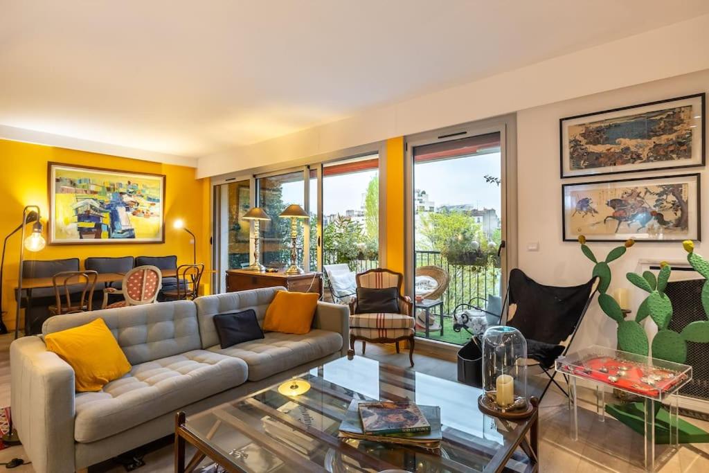 un salon avec un canapé et une table dans l'établissement L'ASSOMPTION Appartement de charme avec balcon, à Paris