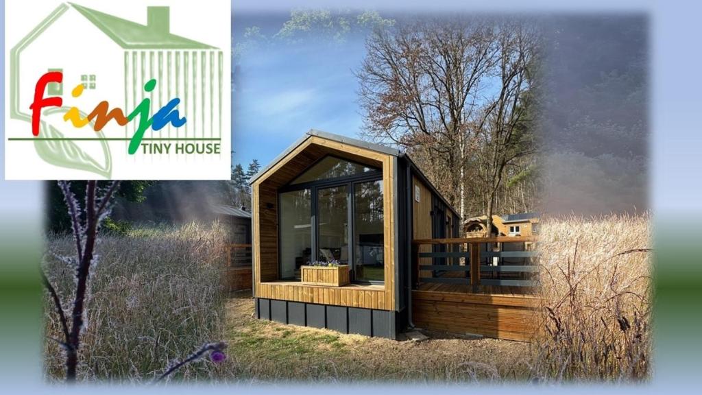 una casa pequeña con una ventana grande en un campo en Tiny House Finja, en Stuer