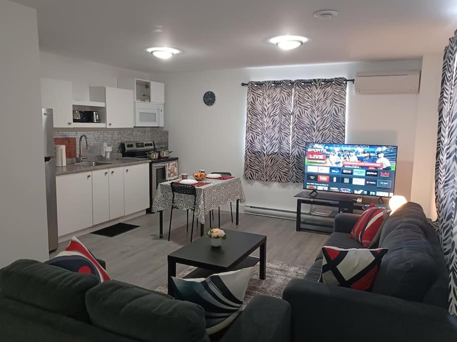 a living room with two couches and a kitchen at Bryana Suite - Comfy 1-Bedroom in Halifax