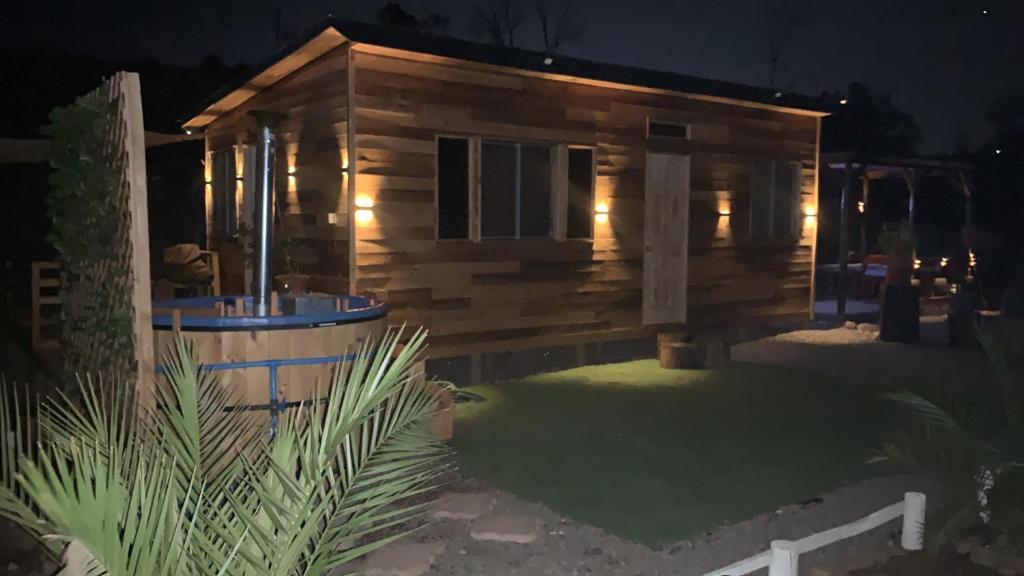 Cabaña de madera con patio por la noche en Tinyhouse Ecologico con Tinaja, en Villa Alemana
