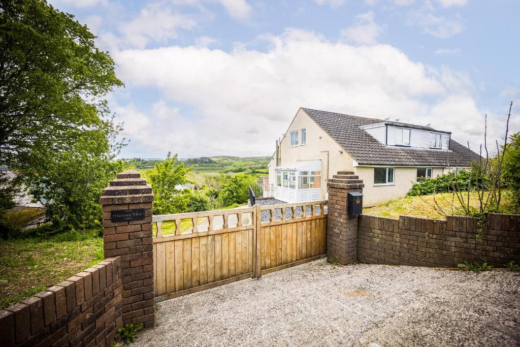 a house with a wooden fence and a gate at Harbour View Goodwick in Goodwick