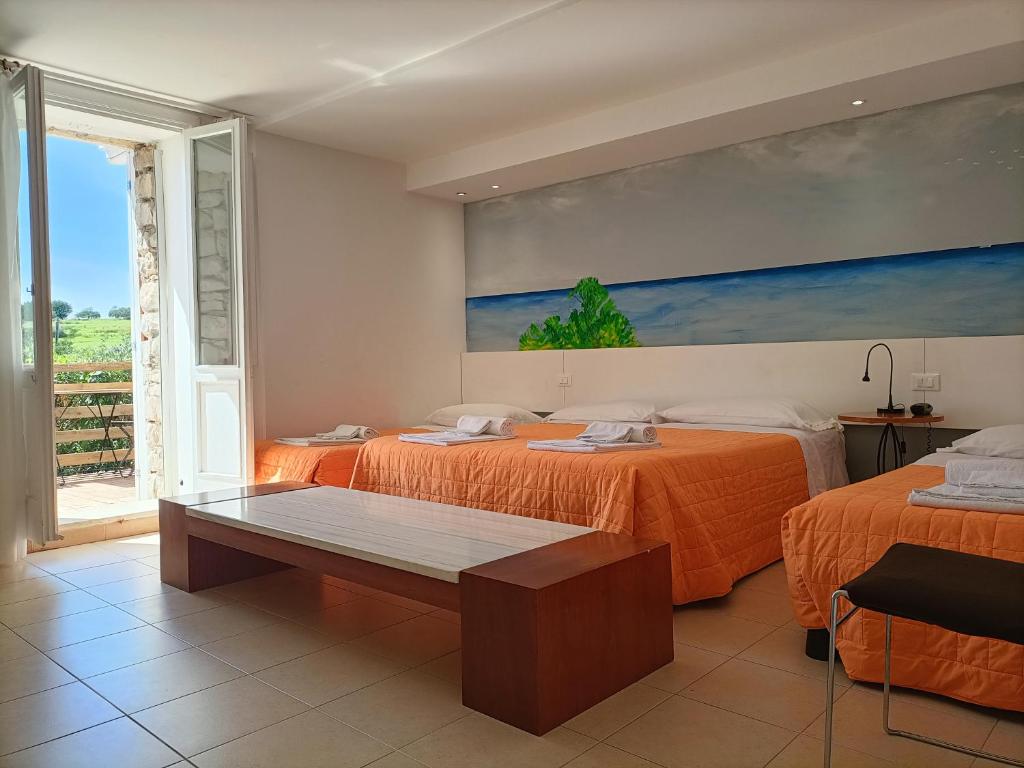 a bedroom with two beds and a painting on the wall at Villa Aurea in Ispica