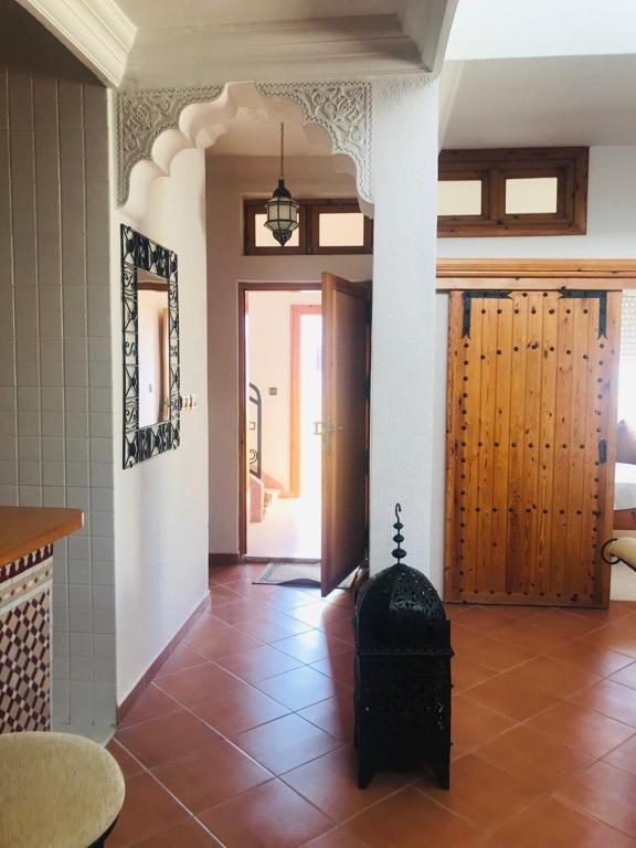 - un salon doté de carrelage et d'une porte ouverte dans l'établissement Appartement atypique et lumineux, à Agadir