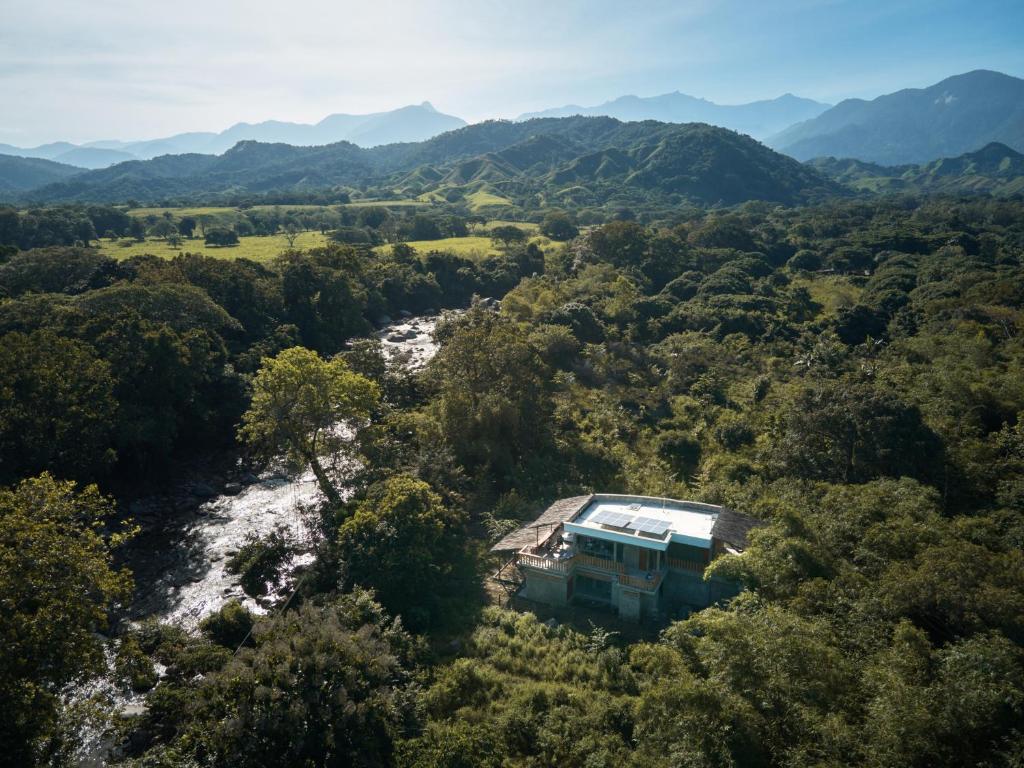eine Luftansicht eines Hauses in der Mitte eines Flusses in der Unterkunft CASA RAÍZ RÍO ANCHO in Mingueo