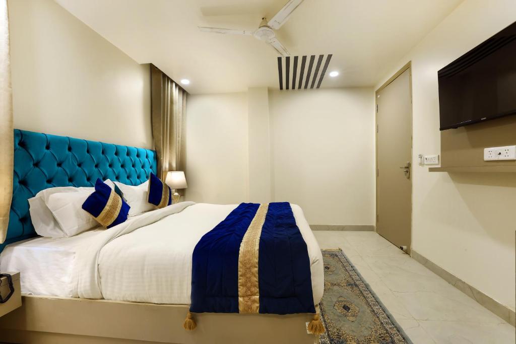 Hotel Black Eye في نيودلهي: غرفة نوم مع سرير كبير مع اللوح الأمامي الأزرق