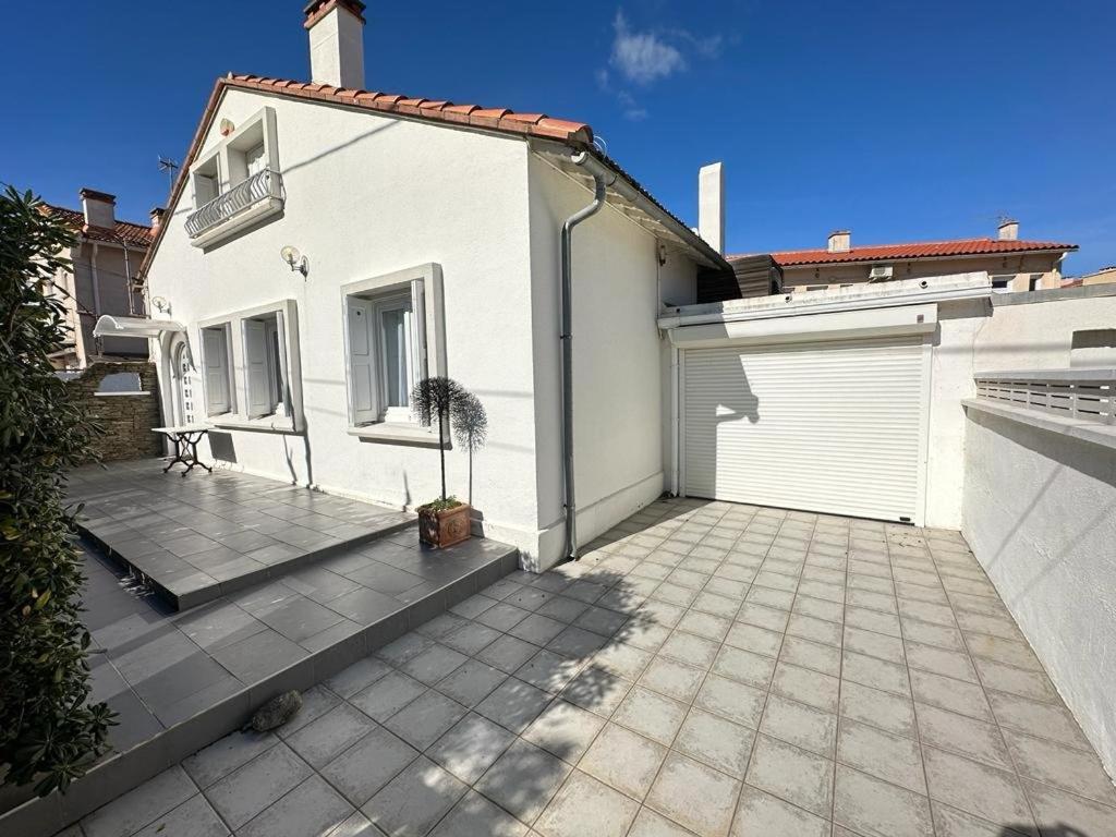 a white house with a patio and a garage at Maison Canétoise familiale 10 min de la plage 6EDGRA20 in Canet-en-Roussillon