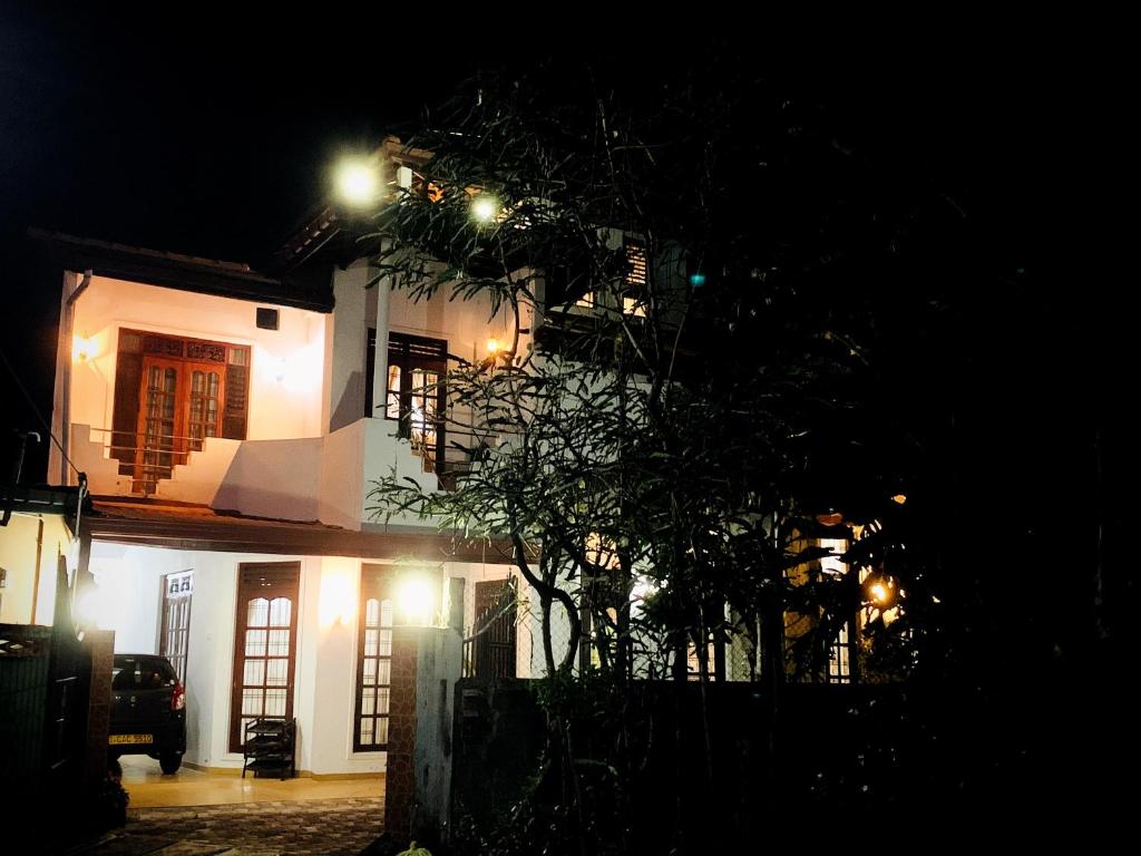 a house at night with a tree in front of it at Matara Near Polhena & Mirissa Three Story House in Matara