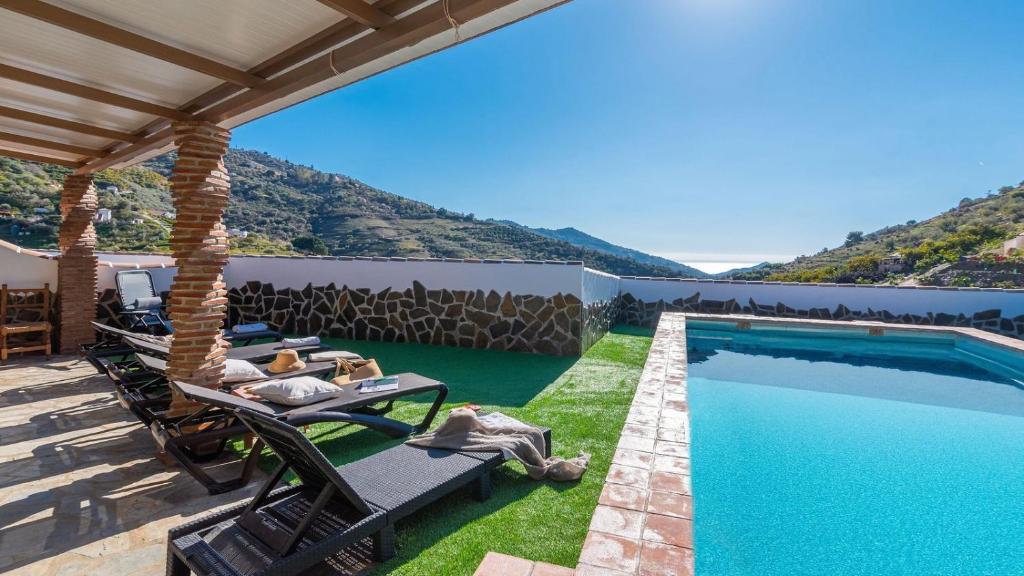a villa with a swimming pool and a patio at Casa La Palma Cómpeta by Ruralidays in Cómpeta