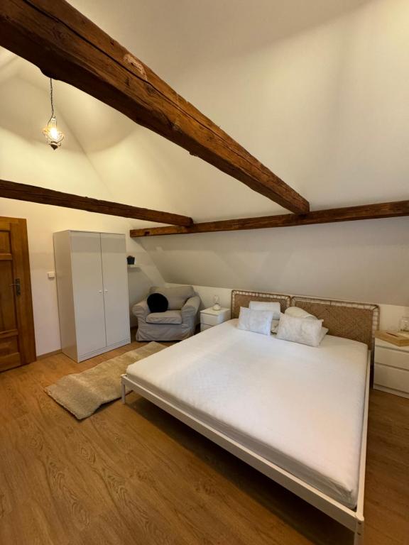 sypialnia z dużym białym łóżkiem na poddaszu w obiekcie V Údolí w mieście Jablonné v Podještědí