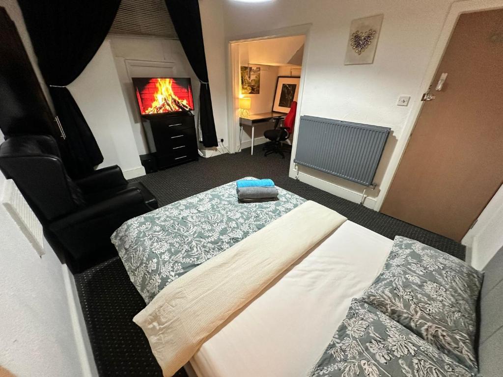 a bedroom with two beds and a fire in the fireplace at Whitechapel Station Rooms R1 in London